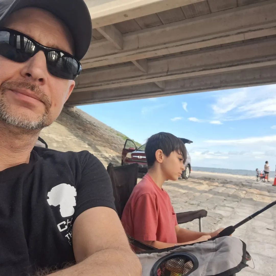 Doug fishing under a bridge with his young son